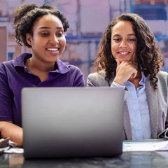 two female workers looking at a computer