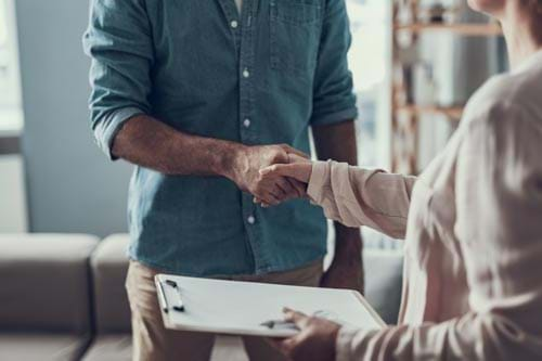 handshake with person holding a clipboard