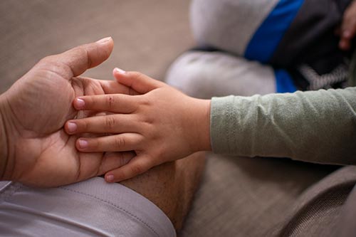 a childs hand inside the palm of adult hand