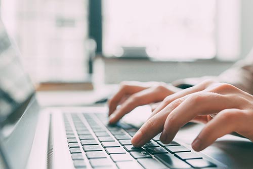 hands typing on a keyboard